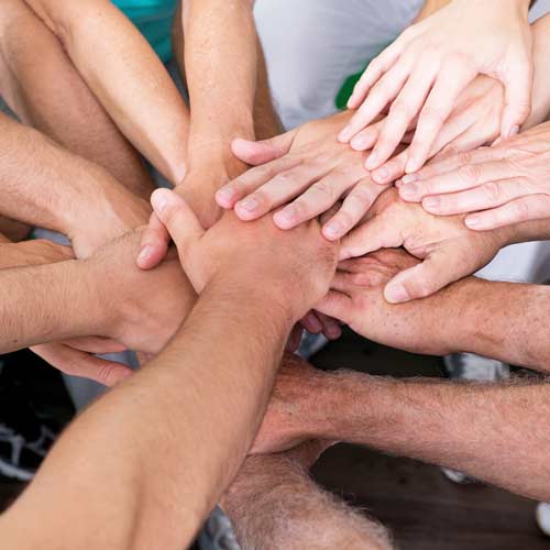 Sich überkreuzende Hände vieler Personen